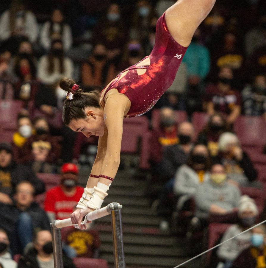 Fifth year gymnast Ona Loper swings on the uneven bars in a meet against the Ohio State Buckeyes on Feb. 12, 2022 at Maturi Pavilion in Minneapolis, Minn.